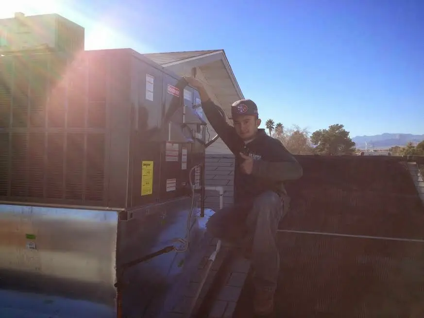 HVAC technician performing HVAC Inspection on a rooftop unit in Butner